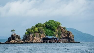 Île tropicale avec végétation luxuriante et cabane en bord de mer en Thaïlande.