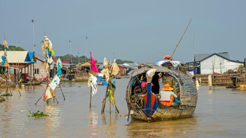 Village flottant au Cambodge avec barques en bois et maisons sur pilotis sur un fleuve