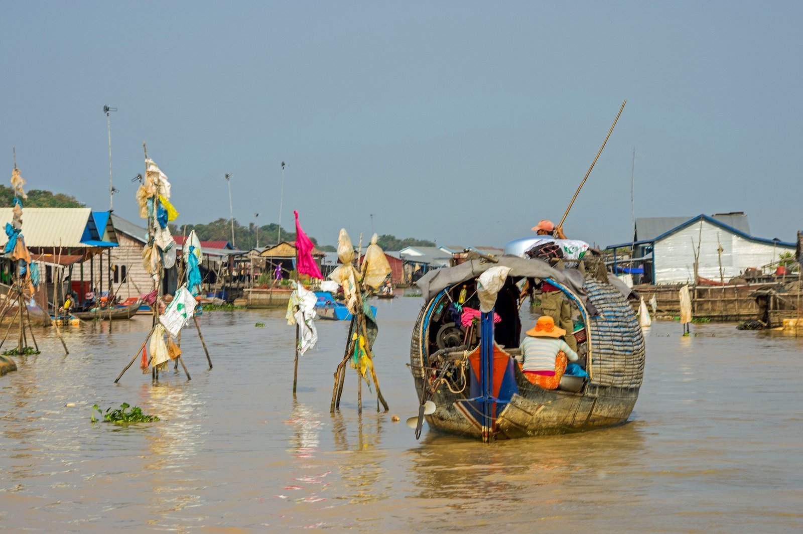 Village flottant au Cambodge avec barques en bois et maisons sur pilotis sur un fleuve