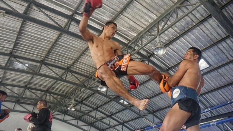 Combat de Muay Thai avec un kick puissant en Thaïlande.