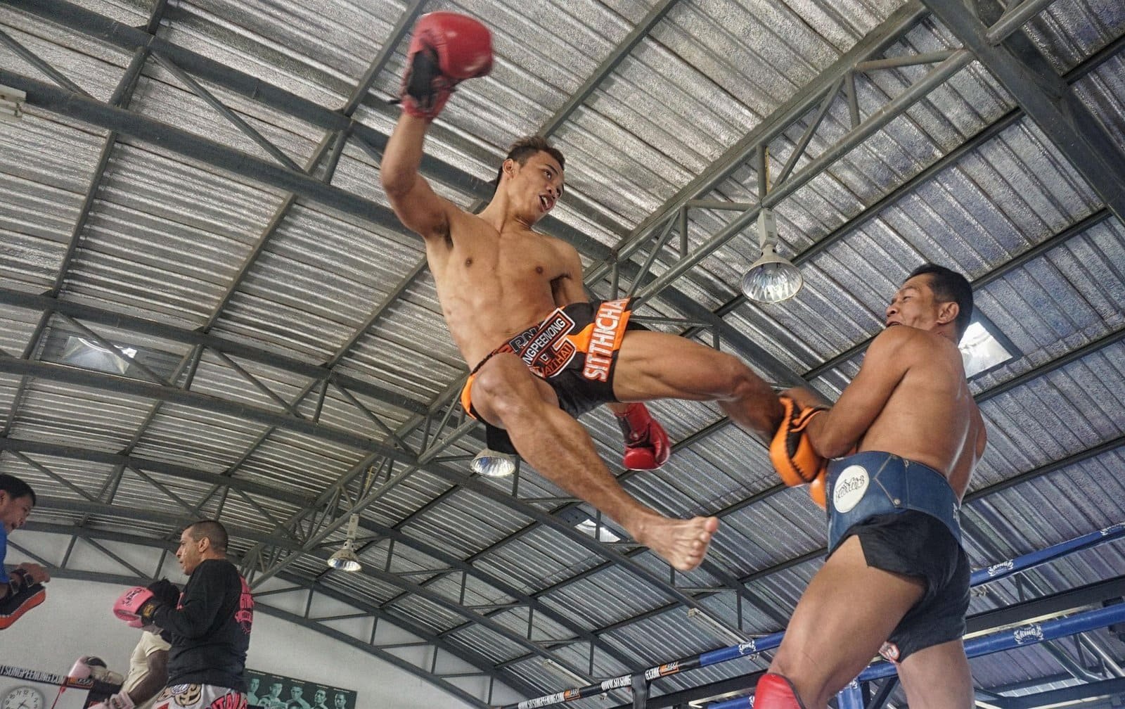 Combat de Muay Thai avec un kick puissant en Thaïlande.