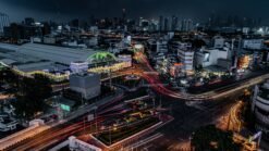 Panorama de Bangkok la nuit avec gratte-ciel et routes illuminées.