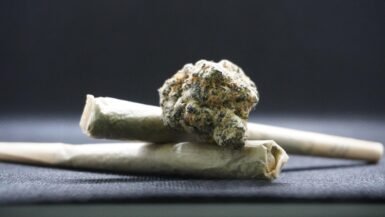 Cannabis en Thaïlande, plante et joint sur fond noir.
