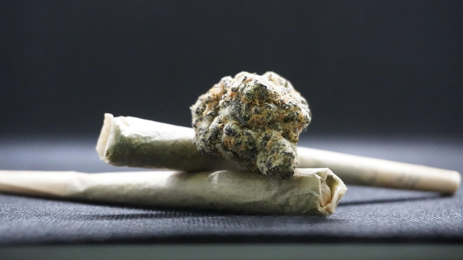 Cannabis en Thaïlande, plante et joint sur fond noir.