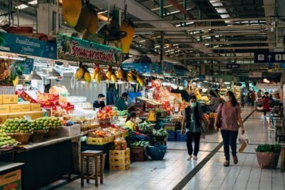 Marché intérieur animé à Bangkok avec fruits et légumes frais.